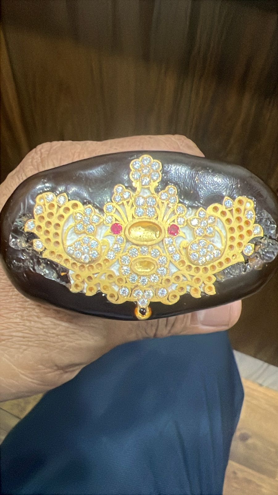 A craftsperson setting diamonds into an intricate gold piece by hand